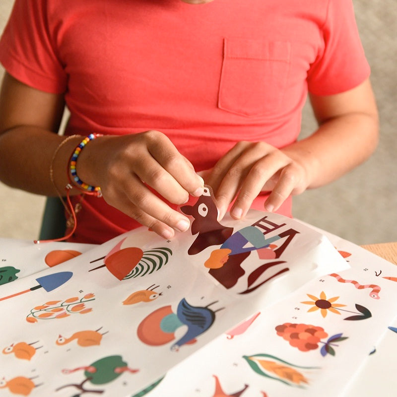 Mains d'enfant avec Affiche découverte et autocollants repositionnables À la ferme