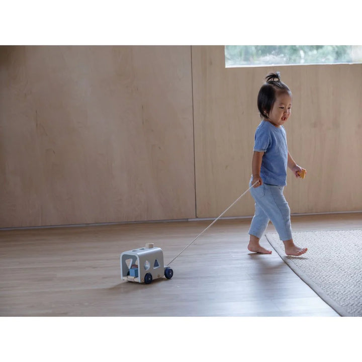 Enfant avec Autobus à formes en bois