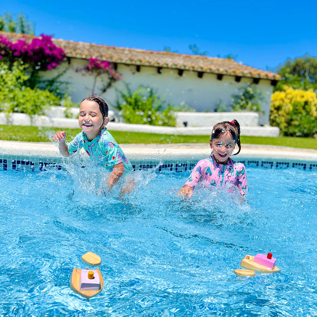 Enfants dans une piscine avec Bateau à remonter en bois