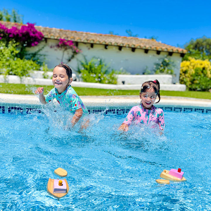 Enfants dans une piscine avec Bateau à remonter en bois