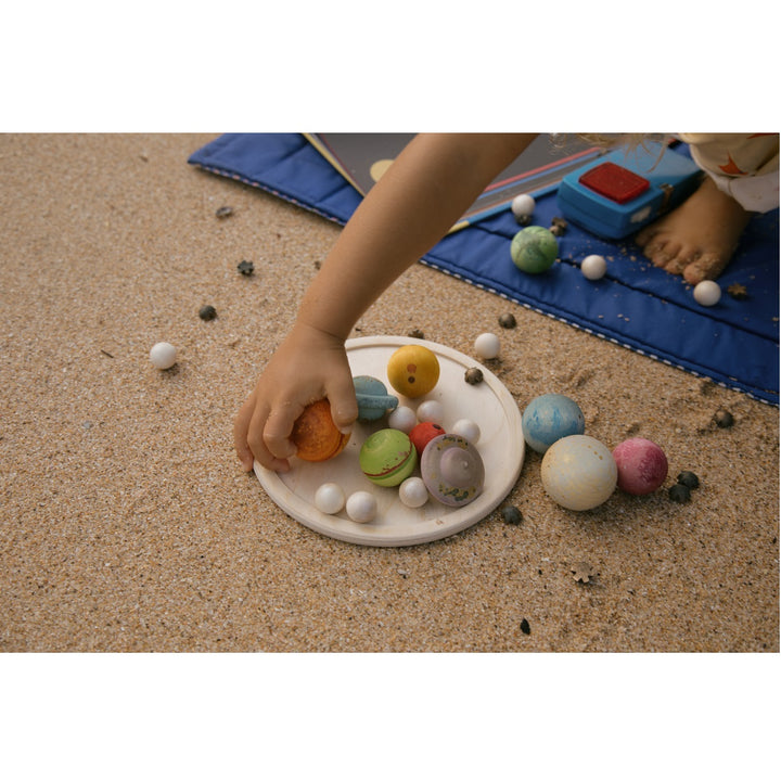 Main d'enfant avec Ensemble en bois Cher Univers