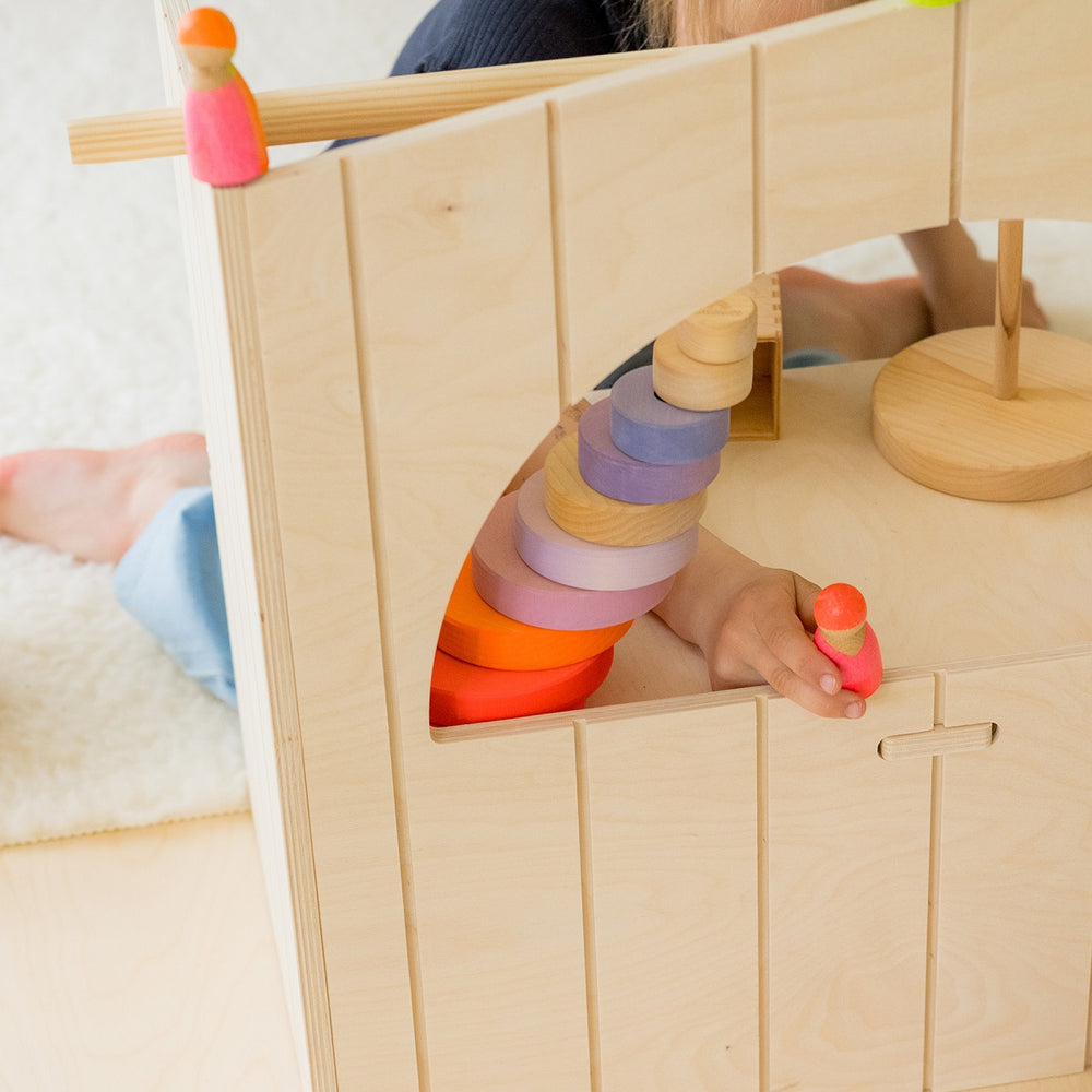 Enfant qui joue avec des Figurines en bois Rose fluo