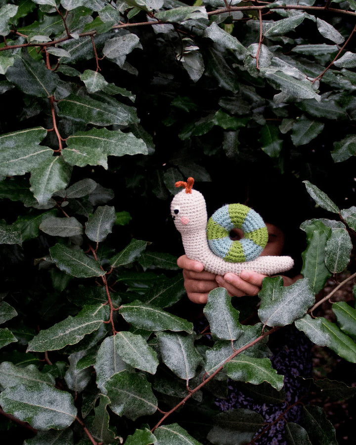 Enfant dans la forêt avec Hochet escargot tricoté dans la