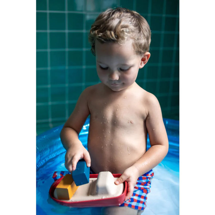 Garçon avec Navire de charge en bois pour le bain