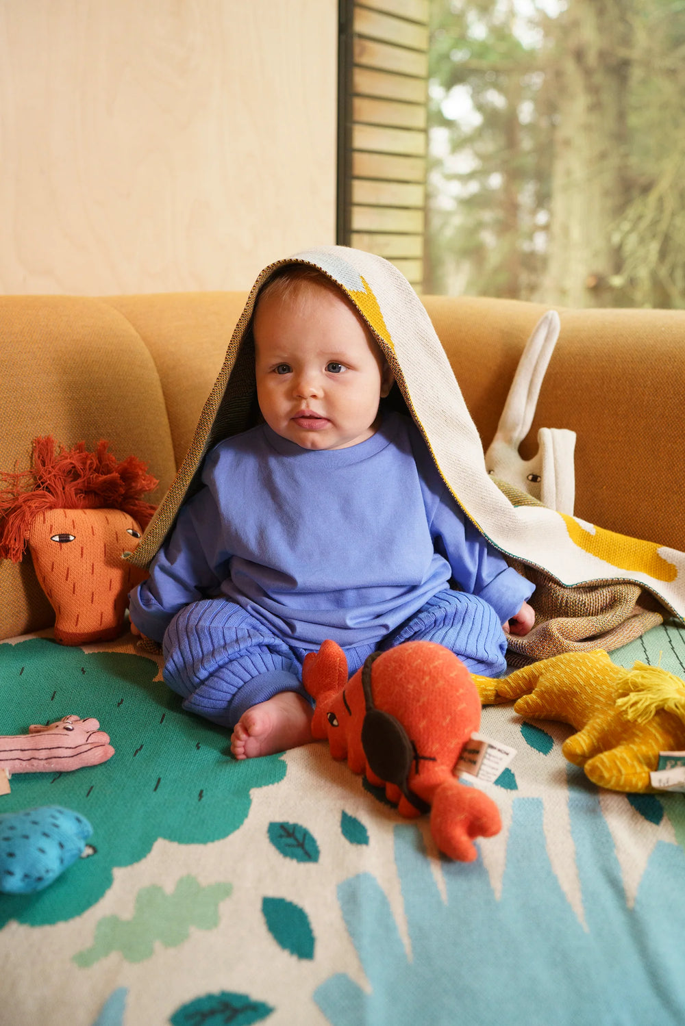 Bébé sur un canapé avec Peluche Donna Wilson en coton bio orange en forme de crabe