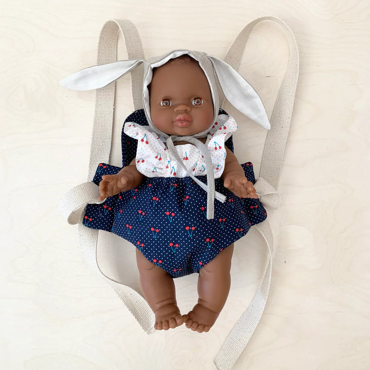 Poupée dans porte-poupée en tissu bleu avec cerises