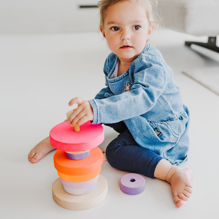 Enfant avec Pyramid conique en bois à empiler Rose fluo