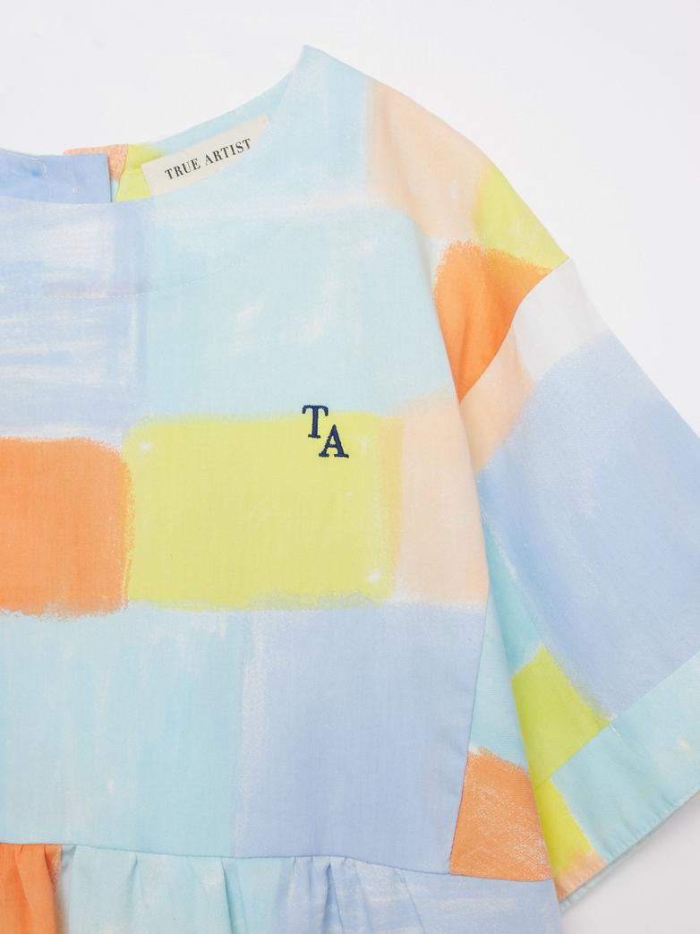Détail de Fille avec Robe True Artist avec tissu coloré orange, jaune, bleu et blanc