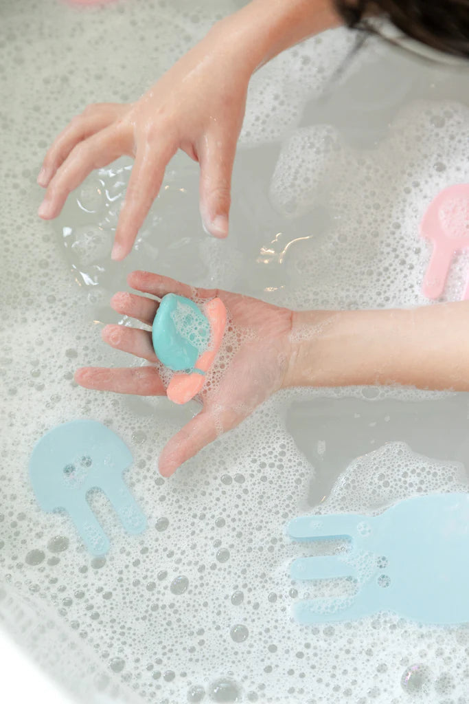Mains d'enfant dans le bain avec Set de pâte de bain et de douche