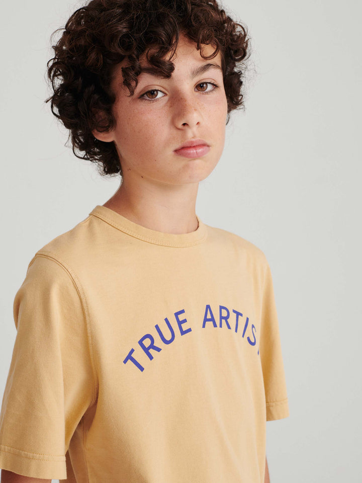 Garçon avec T shirt en coton caramel avec logo True Artist en bleu