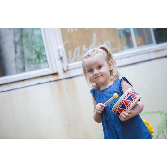 Fille qui joue un Tambour en bois