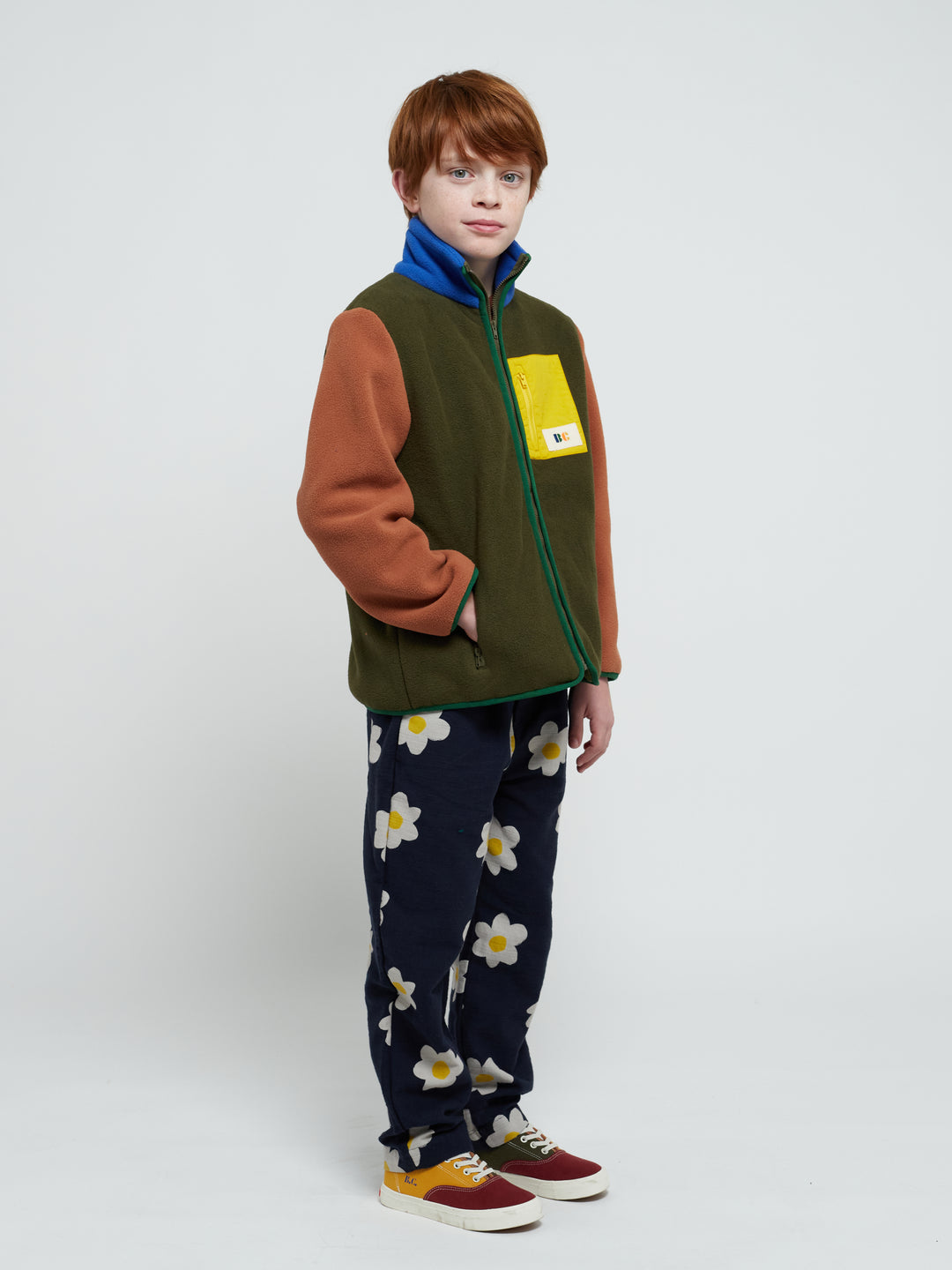 Enfant qui porte un Veste en polaire kaki, brun, bleu, vert et jaune 
