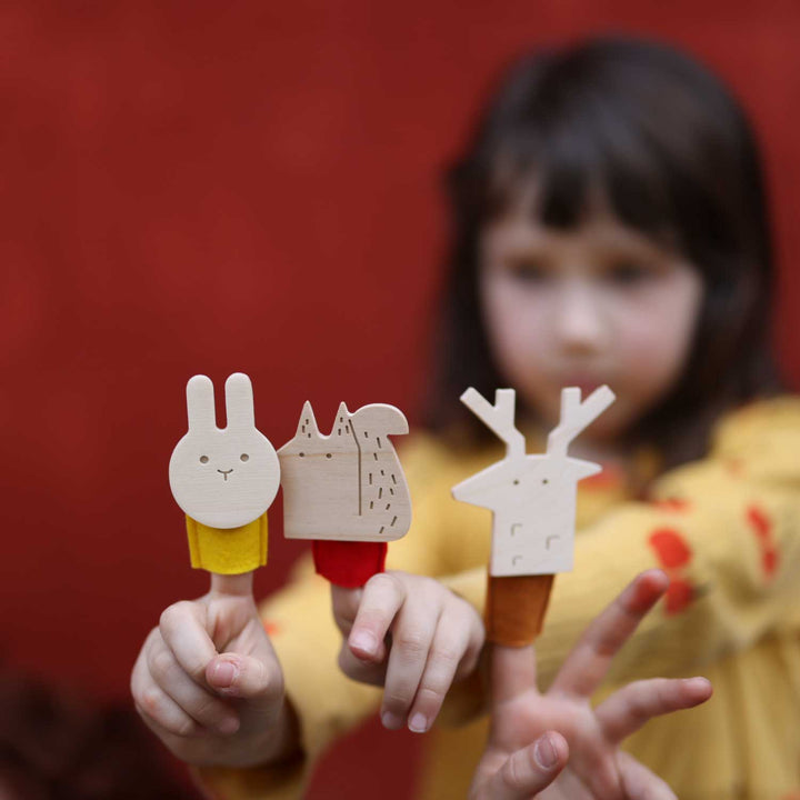 Fille avec marionnettes à doigt lapin, écureuil et cerf