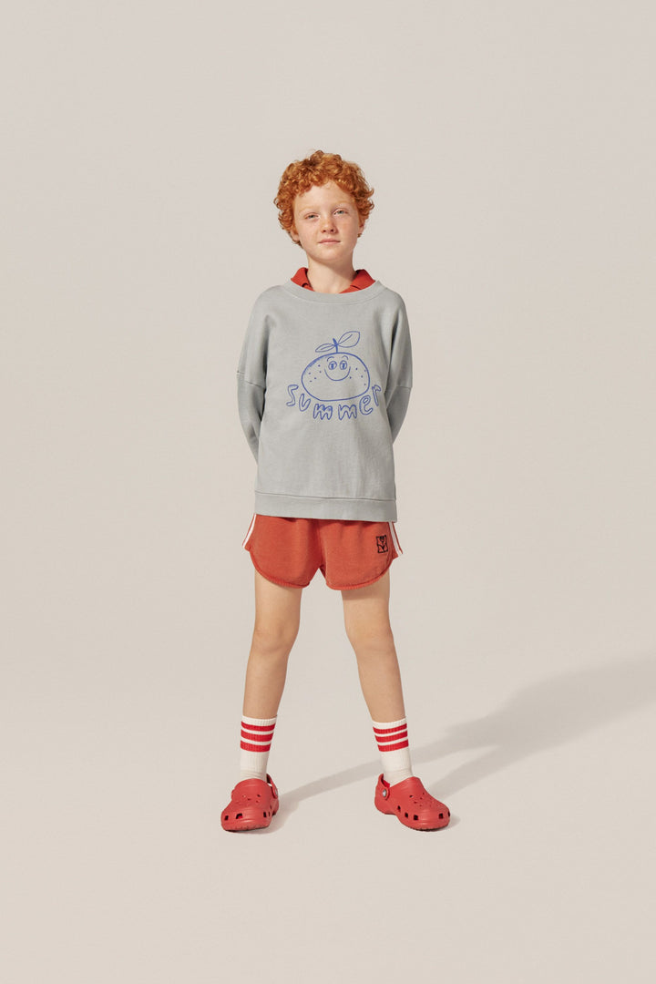 Garçon avec Short sportif en coton rouge délavé