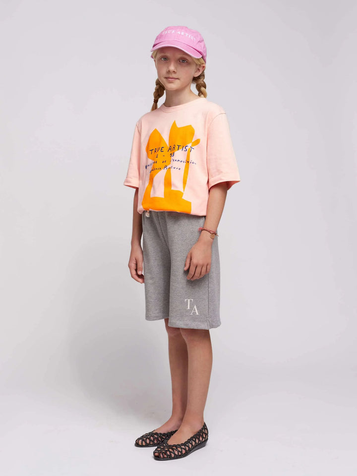 Fille avec T-shirt en coton biologique saumon doux avec imprimé True Artist sur le devant
