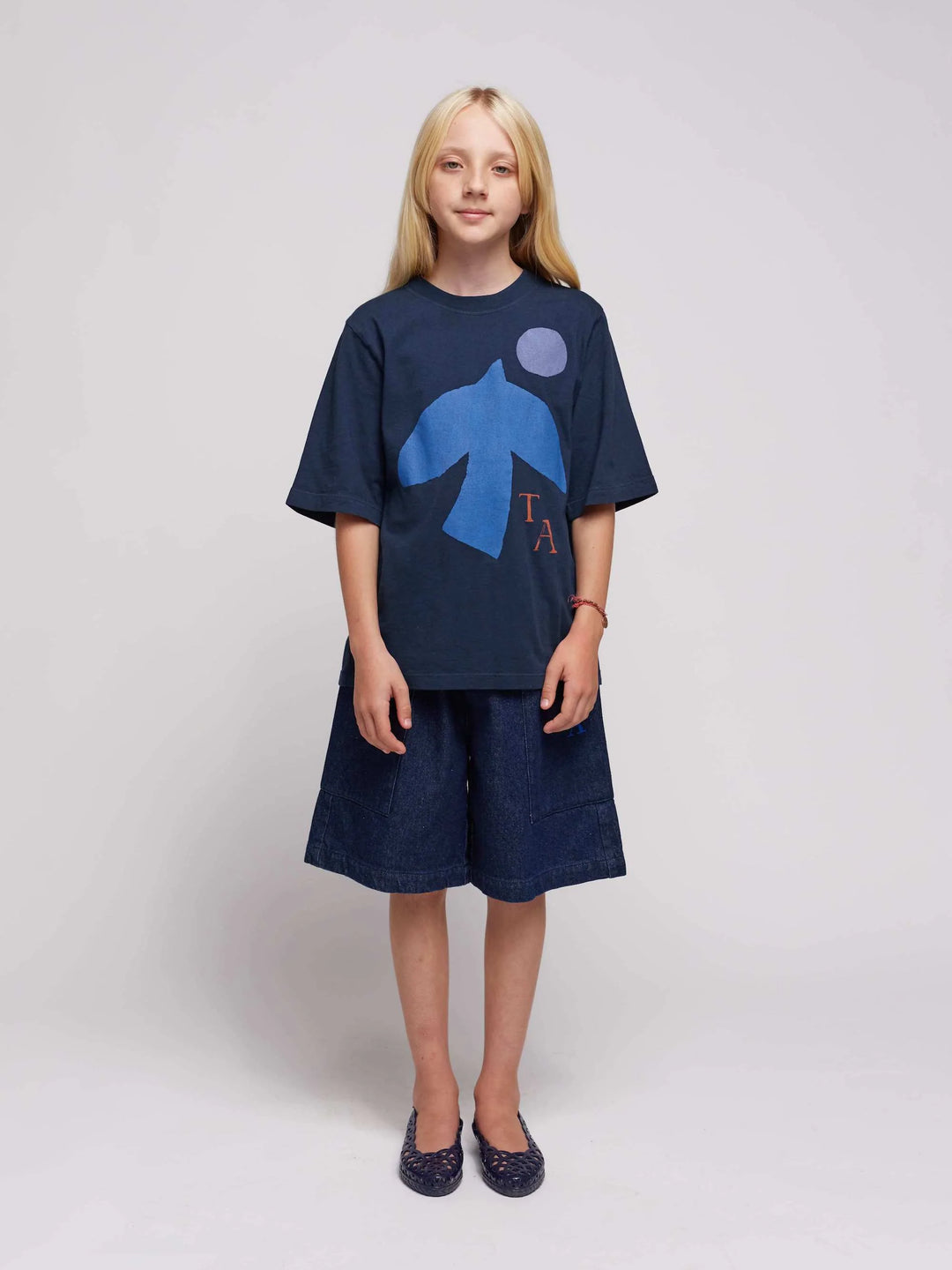Fille avec T-shirt pour enfant en coton bleu marin avec imprimé oiseau bleu et shorts en denim