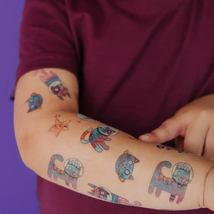 Bras d'un enfant avec Tatouages temporaires Les chats de l'espace