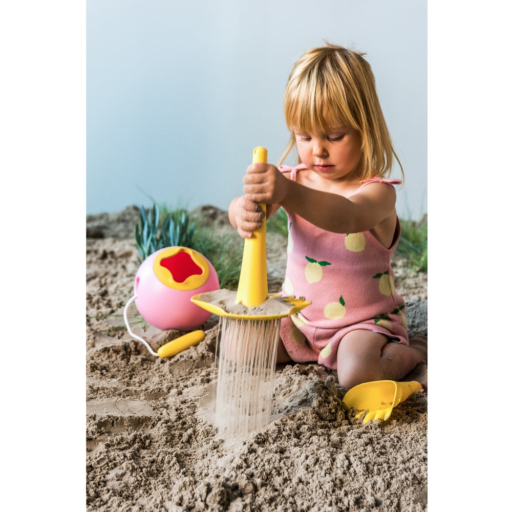 Enfant avec triplet jaune dans le sable