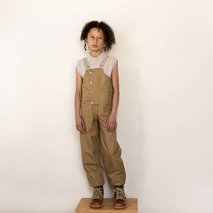 kid posing with fairechild kids rain dungarees in enfant posant avec un pantalon de pluie pour enfant