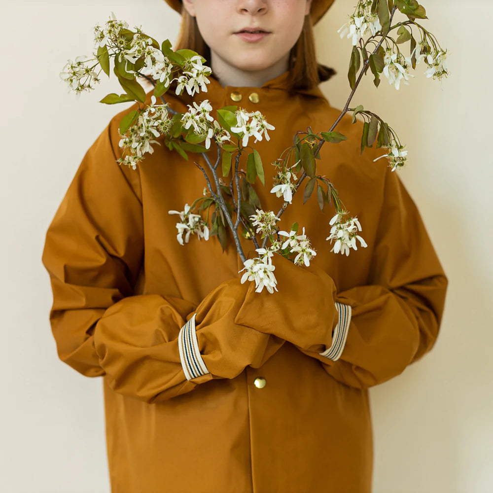 Child posing wearing faire child rain mittens mitaines de pluie arbousier