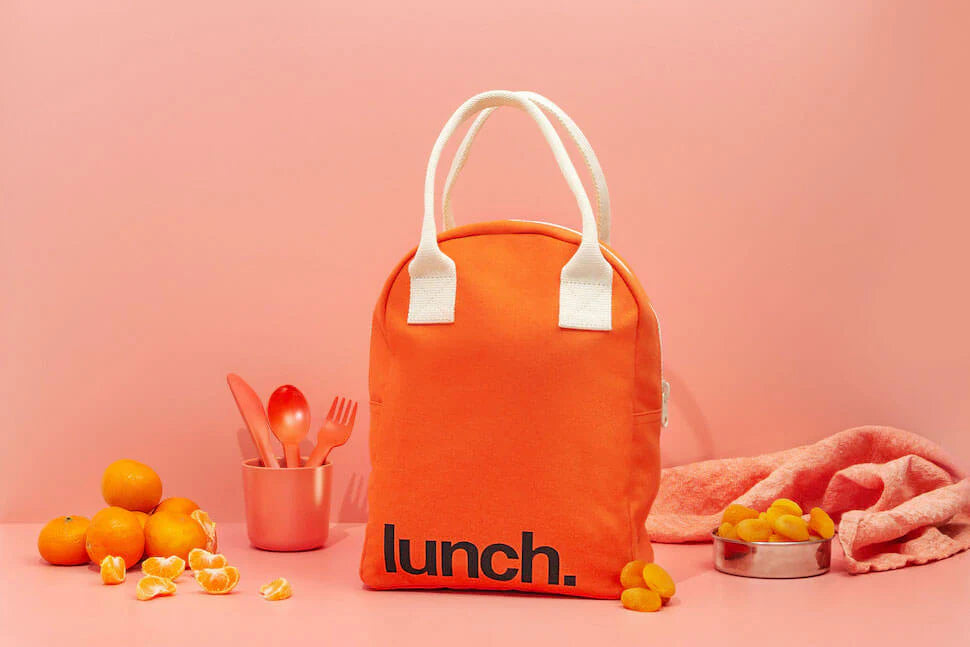 Boîte à lunch en coton orange sur une table avec des fruits