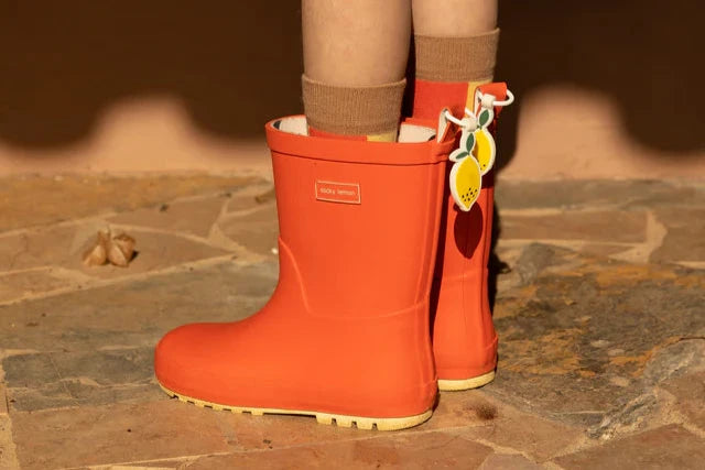 Jambes d'enfant avec Bottes de pluie en caoutchouc orange 
