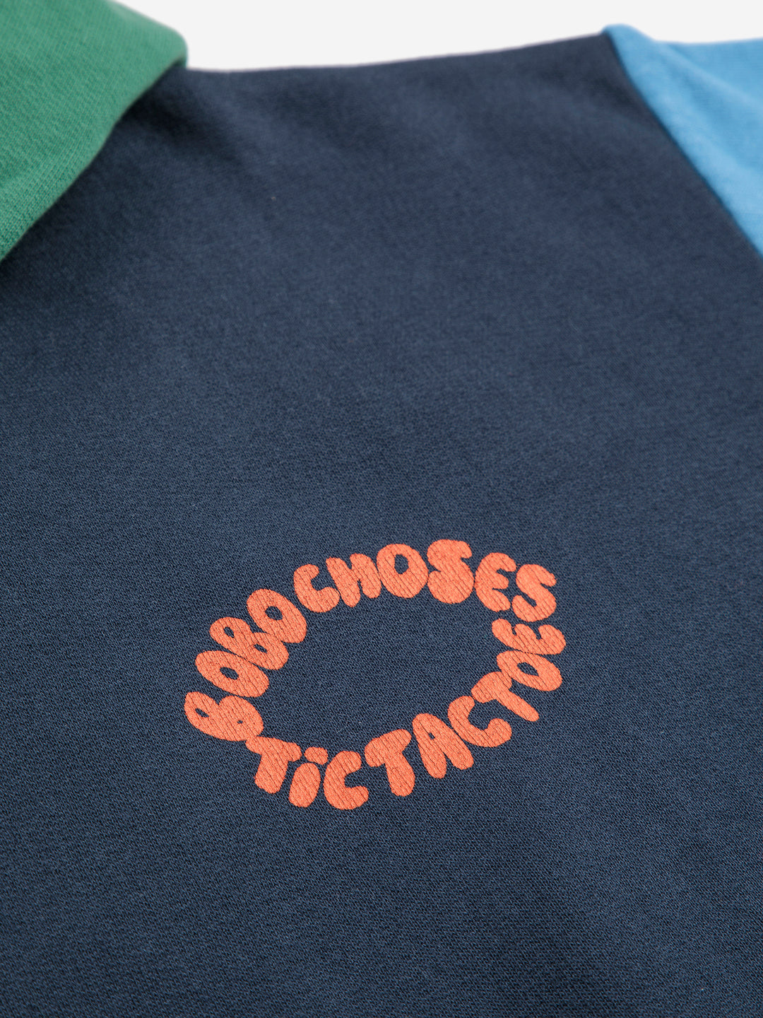 Détail du logo du Chandail à capuche Bobo Choses en coton bleu et vert