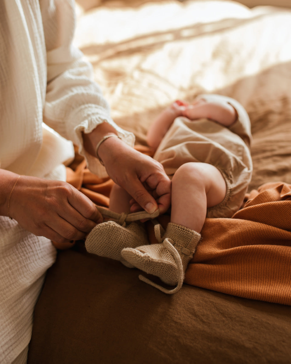 Bébé avec Chaussons de laine de mérinos sable