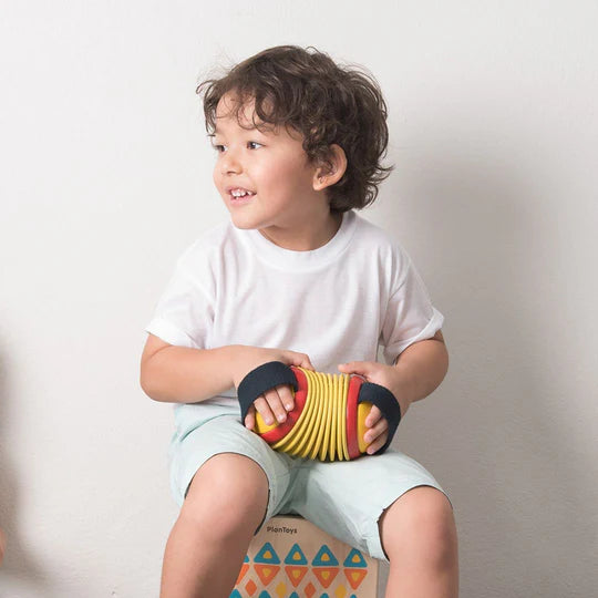 Garçon avec Jouet musical accordéon concertina de Plan Toys