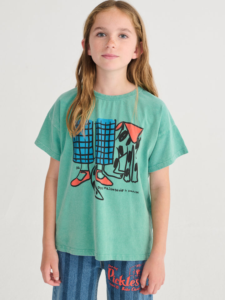 Enfant avec T-shirt Bobo Choses en coton vert avec imprimé chien et jambes d'enfant