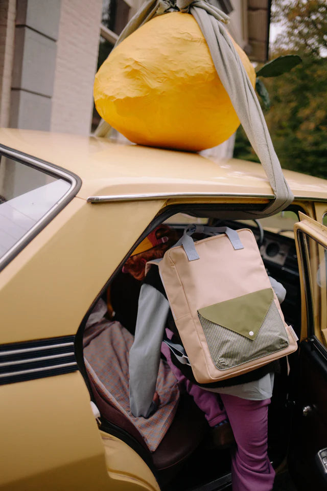 Enfant qui rentre dans une voiture avec Sac à dos Sticky Lemon Large beige, vert et mauve
