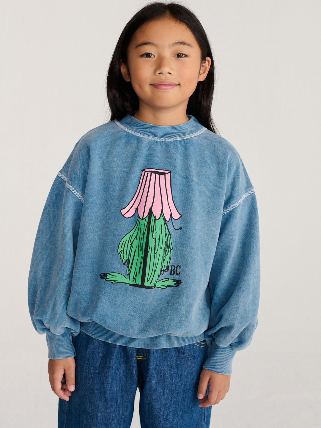 Fille avec Chandail Bobo Choses bleu avec monstre vert caché dans une lampe