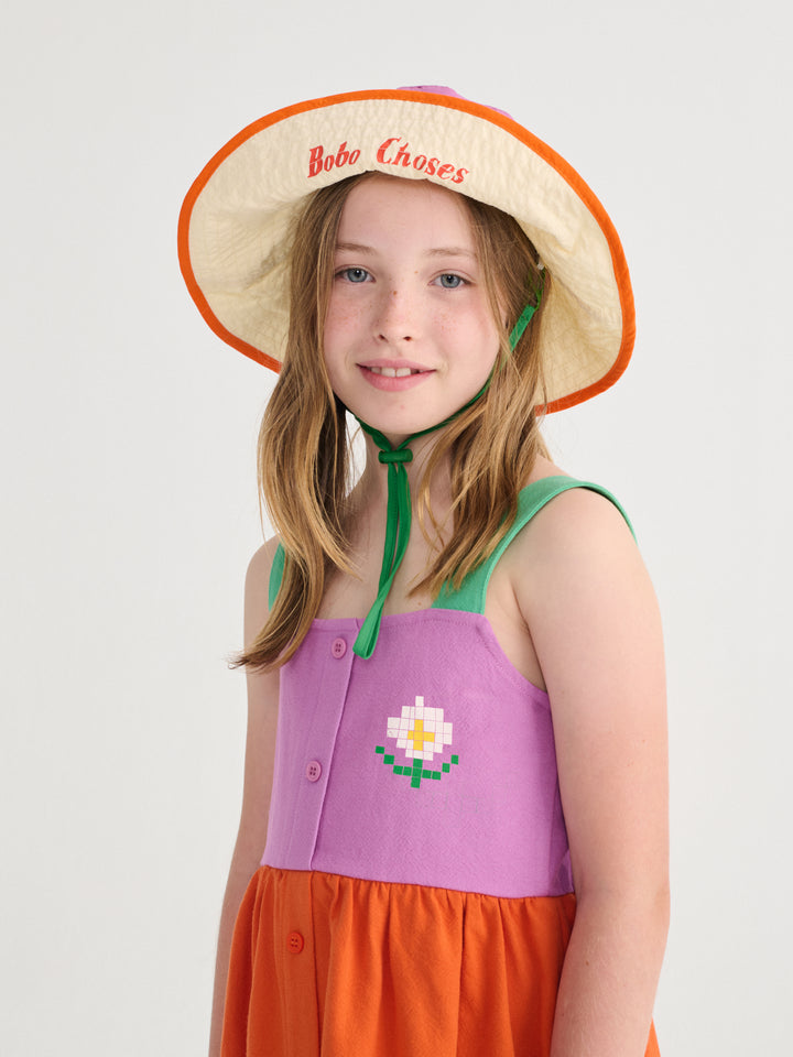 Fille avec Robe Bobo Choses en coton orange, rose et vert avec une marguerite imprimée