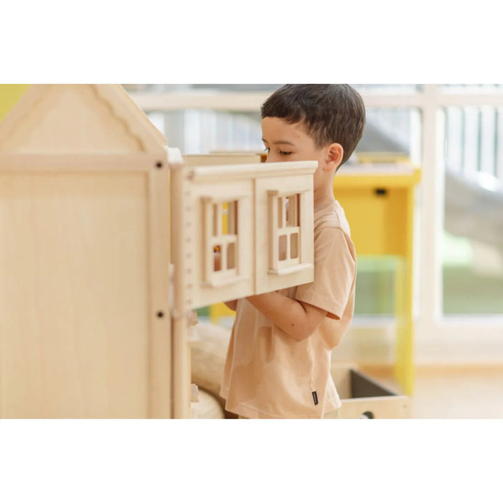 Garçon qui joue avec Grande maison de poupées victorienne