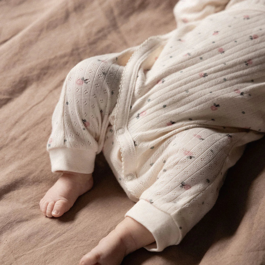 Jambes de bébé avec Pyjama kimono pointelle Nature Baby en coton blanc avec imprimé fleurs roses