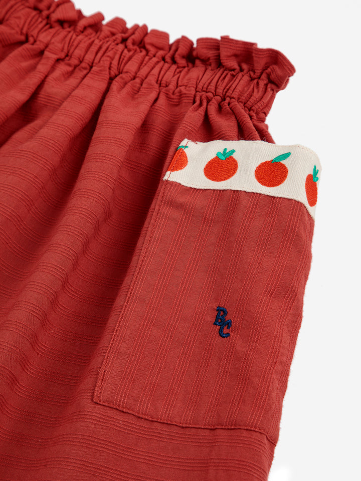 Jupe en coton rouge avec pochettes avec des petites tomates 