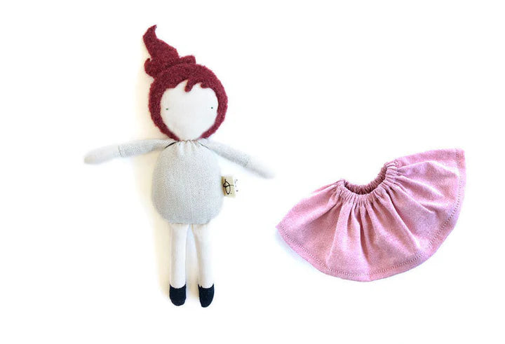 Mini poupée en laine et coton avec les cheveux longs rouges, la peau claire et une jupe rose