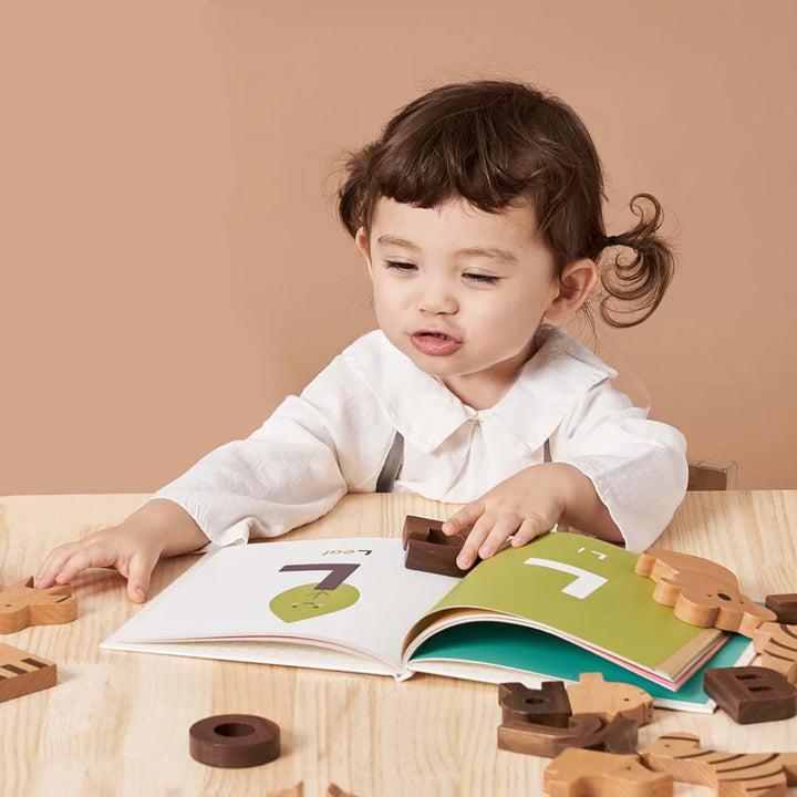 Enfant qui joue avec an Alphabet book et des blocks alphabet 