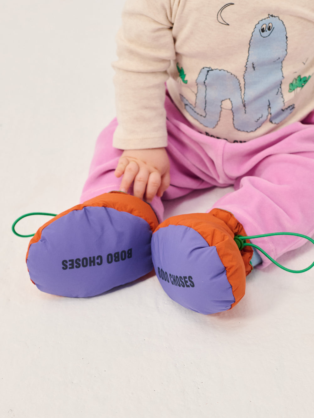 Pieds de bébé avec Chaussons Bobo Choses matelassés orange, mauve et vert
