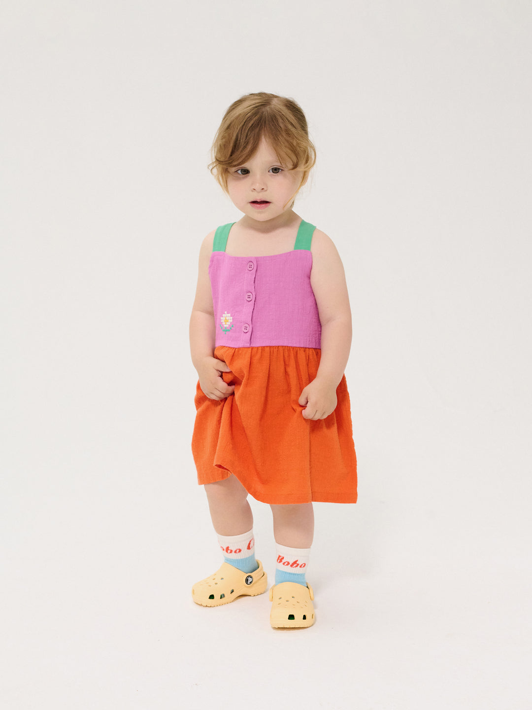 Fille avec Robe Bobo Choses en coton orange, rose et vert avec un marguerite tissée