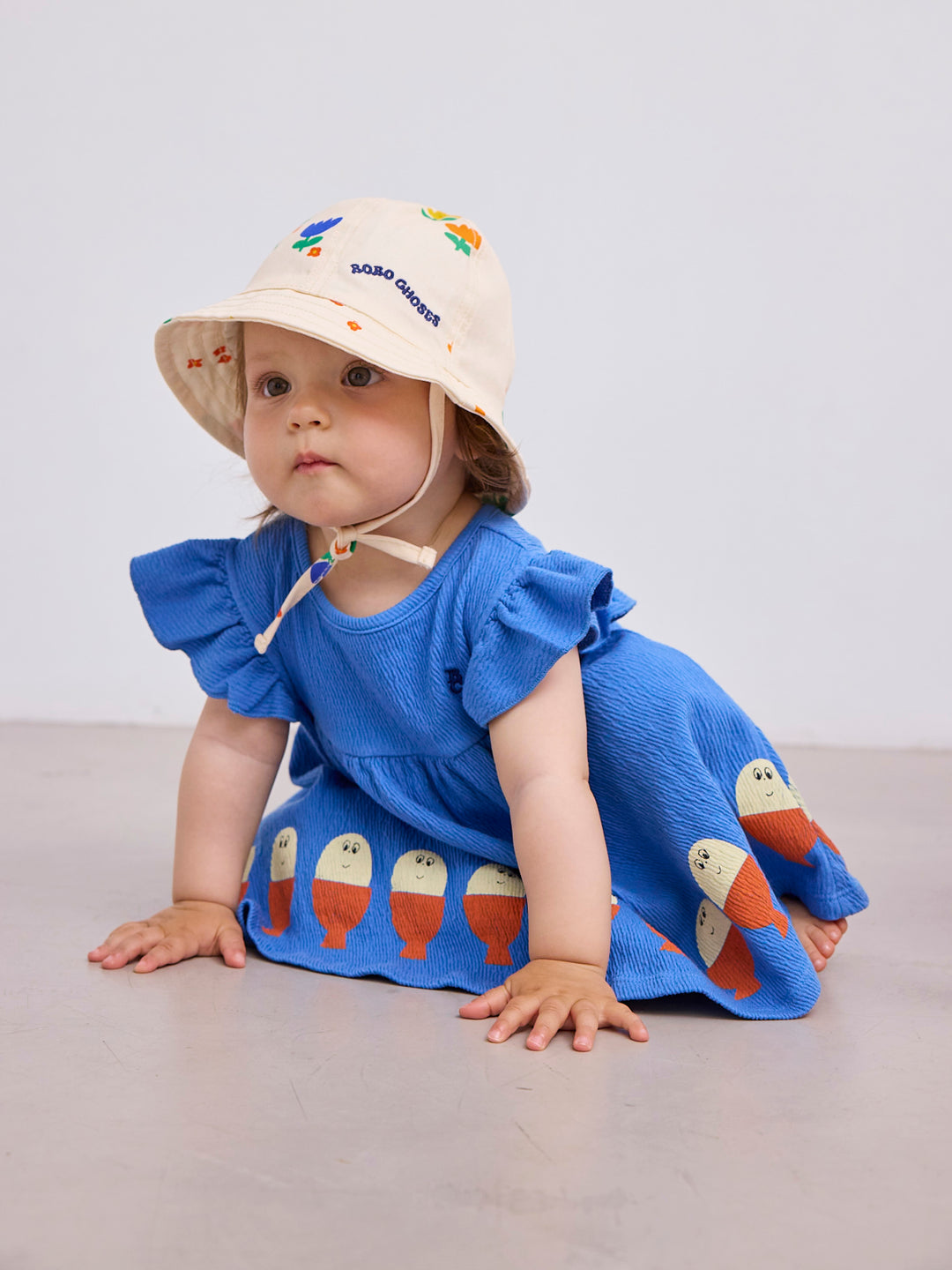 Bébé avec Robe pour bébé bleue avec imprime poissons rouges et blancs 