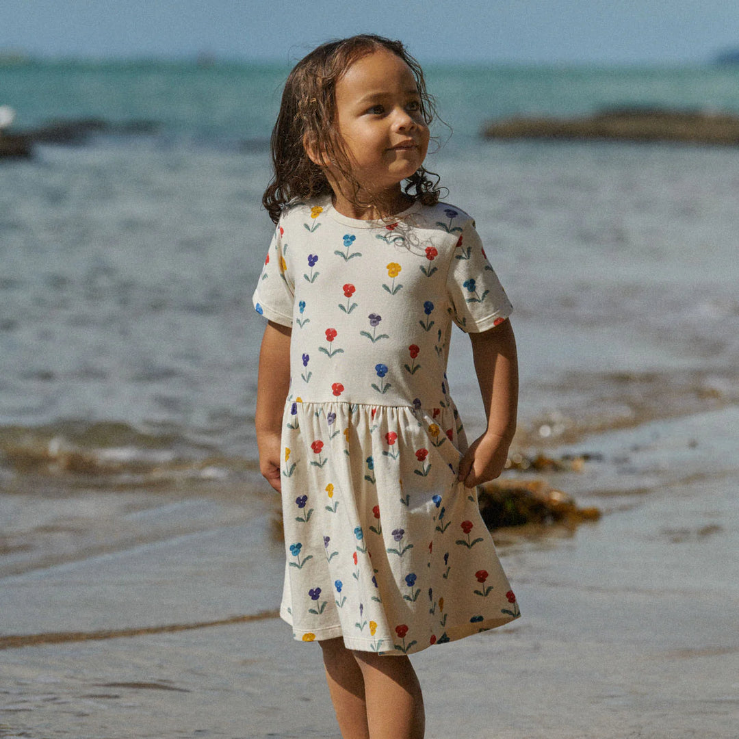 Fille à la plage avec Robe pour enfant Nature Baby en coton blanc imprimé fleurs 