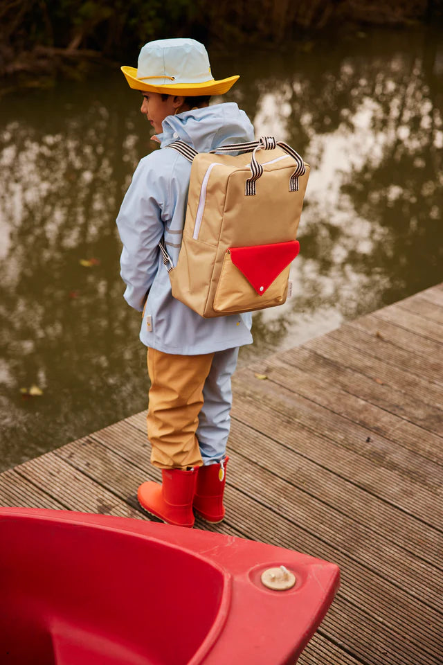 Enfant au bord d'un lac avec Large Sac à dos Sticky Lemon jaune, rouge et beige