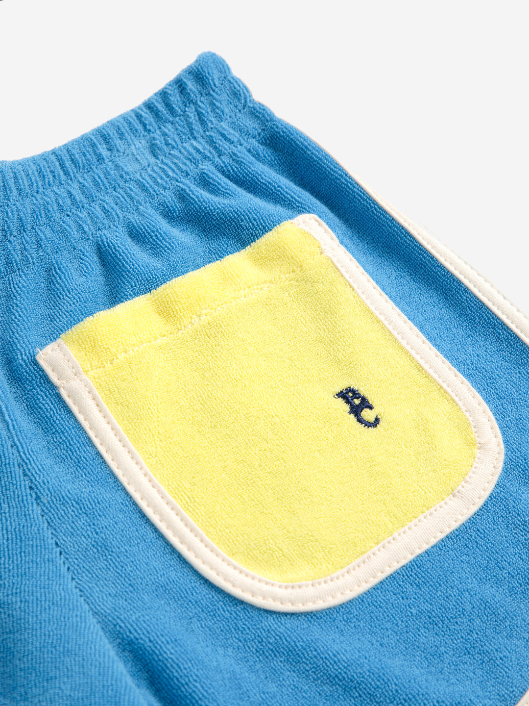 Détail de Short en ratine bleu avec pochettes jaunes