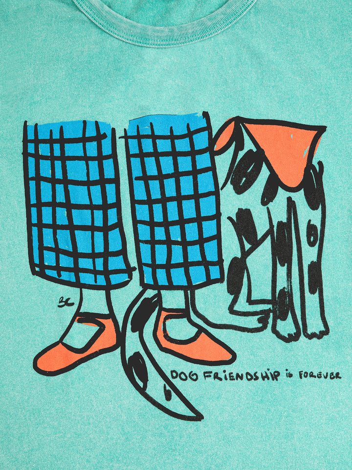Détail de t-shirt Bobo Choses en coton vert avec imprimé chien et jambes d'enfant