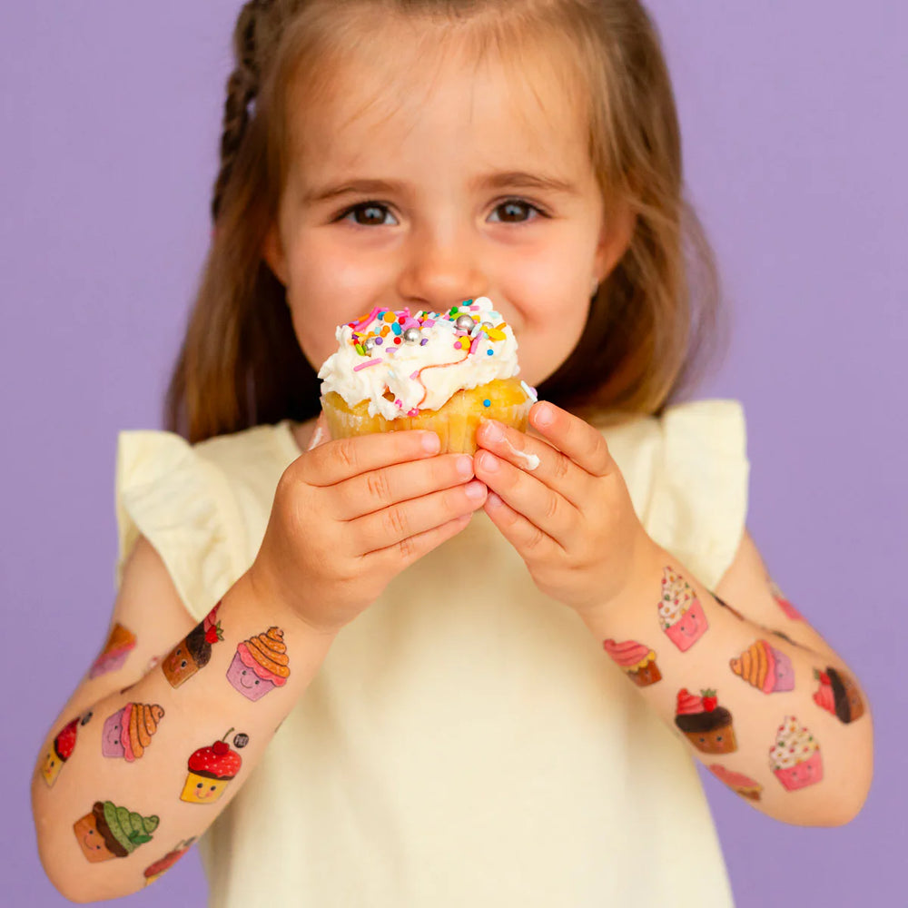 Fille avec Tatouages temporaires des petits gâteaux gourmands