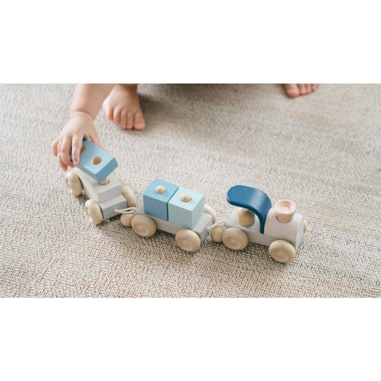 Mains de bébé avec Trio de trains en bois à empiler