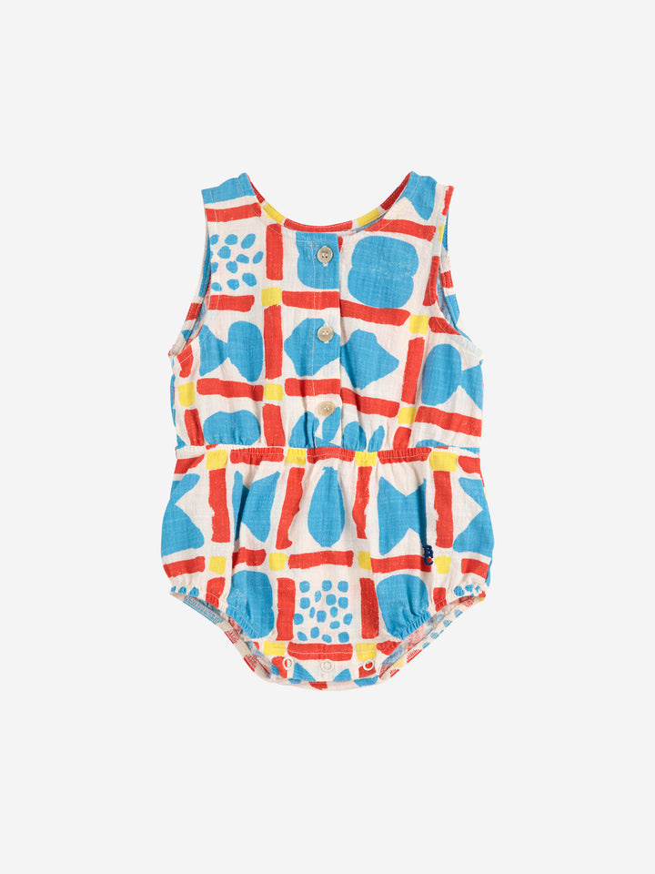 Une-pièce pour bébé en coton blanc avec un motif géométrique bleu, rouge et jaune