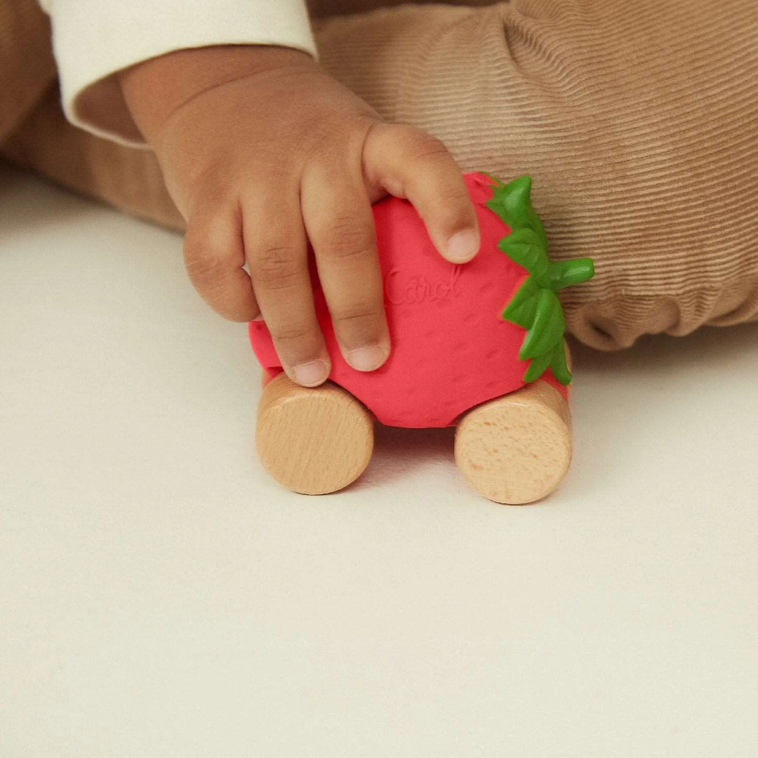 main de bébé avec Voiture pour bébé en caoutchouc en forme de fraise