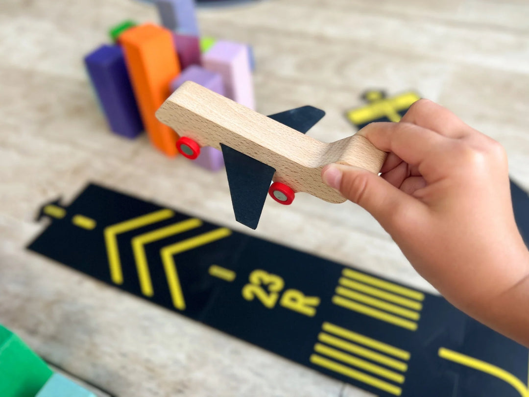 Main d'enfant avec Avion en bois